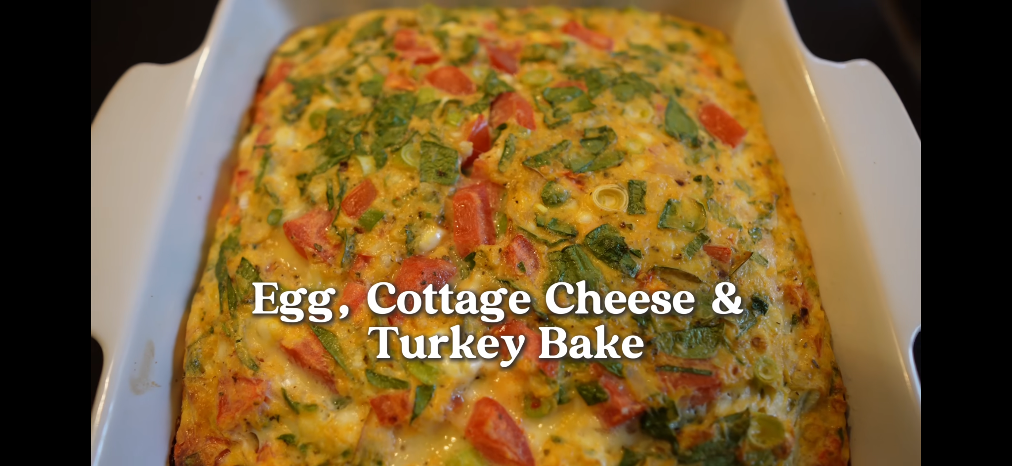 High-protein breakfast casserole with eggs, cottage cheese, turkey, tomatoes, scallions, and cheddar
