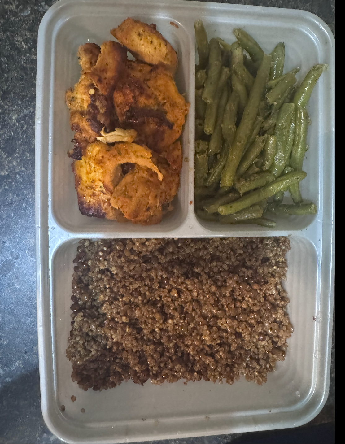 Meal prep container with seasoned chicken, quinoa and green beans